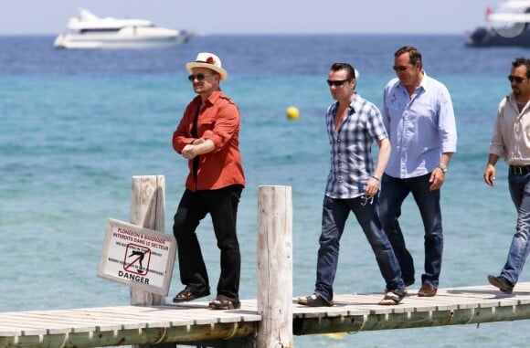 Le chanteur Bono, sa femme Alison Hewson et Larry Mullen (batteur du groupe U2, chemise bleue à carreaux) arrivent au Club 55, plage de Pampelonne à Ramatuelle, le 04 juillet 2013.