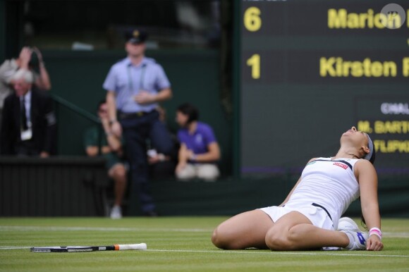 Marion Bartoli, à terre sur la pelouse de Wimbledon après sa victoire en demi-finale face à Kirsten Flipkens au All England Lawn Tennis and Croquet Club de Londres, le 4 juillet 2013
