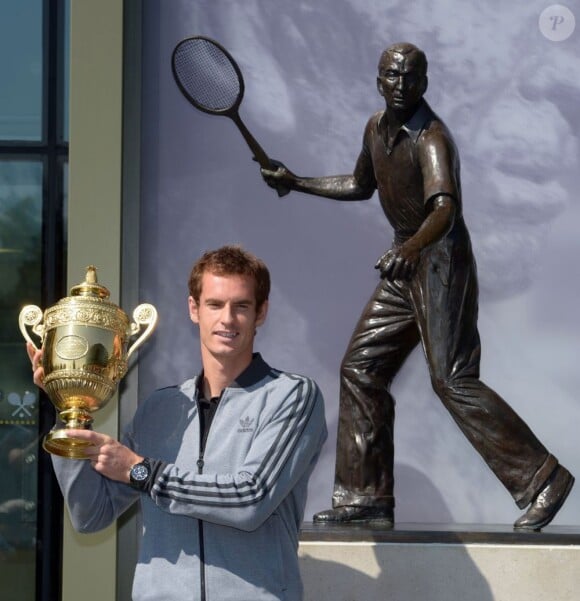 Andy Murray prend la pose avec son trophée de Wimbledon devant la statue de Fred Perry au All England Lawn Tennis and Croquet Club de Wimbledon à Londres le 8 juillet 2013