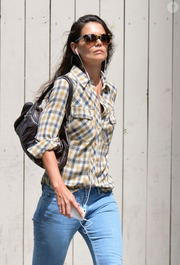 L'actrice Katie Holmes, matinale, seule dans les rues de New York. La maman de Suri Cruise, très décontractée en jean et chemise à carreaux, n'a pas lâché du regard les paparazzi. Le 12 juillet 2013.