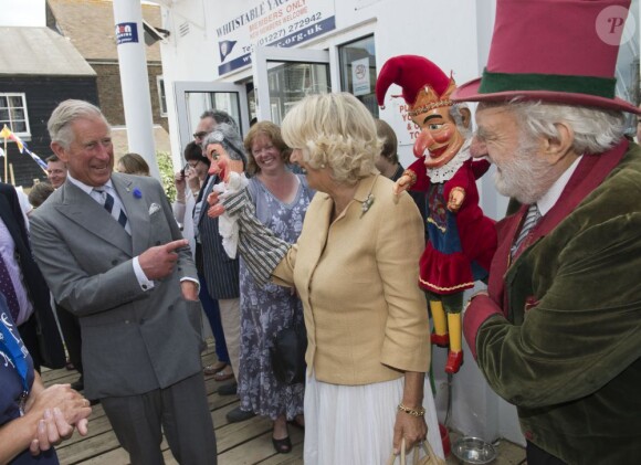 Le prince Charles, accompagné de son épouse Camilla Parker Bowles, au Festival de l'huître de Whitstable, dans le Kent, le 29 juillet 2013. Une sortie à l'occasion de laquelle il a confié que son petit-fils le prince George serait en un rien de temps surnommé Georgie.