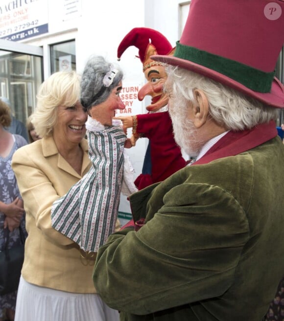 Le prince Charles, accompagné de son épouse Camilla Parker Bowles, au Festival de l'huître de Whitstable, dans le Kent, le 29 juillet 2013. Une sortie à l'occasion de laquelle il a confié que son petit-fils le prince George serait en un rien de temps surnommé Georgie.