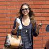 Jessica Alba, souriante à Santa Monica, porte un sac WP M signé Louis Vuitton, un jean évasé Level 99 et des sandales/espadrilles à semelles compensées Ralph Lauren. Le 24 juillet 2013.