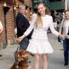 Amanda Seyfried souriante avec son chien Finn au Ed Sullivan Theater, porte un ensemble Balmain (collection Resort 2014) et des escarpins Rupert Sanderson. New York, le 30 juillet 2013.