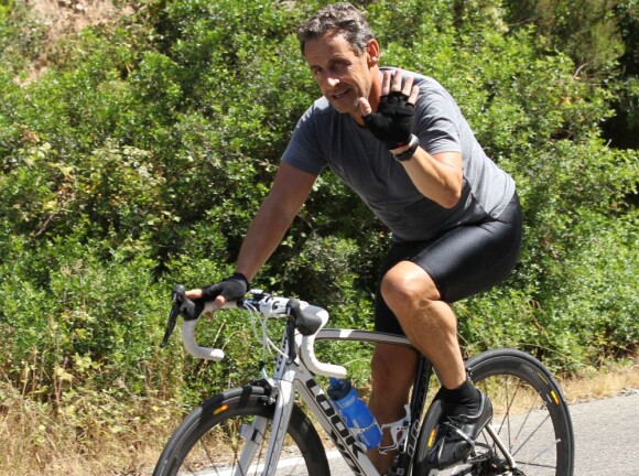Nicolas Sarkozy salue le photographe pendant ses vacances au Cap Nègre près de Cavalaire, le 3 août 2013.