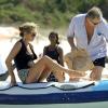 Kate Moss grimpe à bord d'un bateau gonflable avec Mario Testino et des membres de sa famille. Le 16 août 2013.