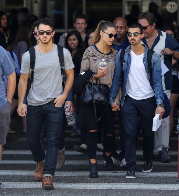 Les Jonas Brothers, Kevin, Nick et Joe avec sa chérie Blanda Eggenschwiler arrivent à l'aéroport de Los Angeles, le 16 août 2013.
