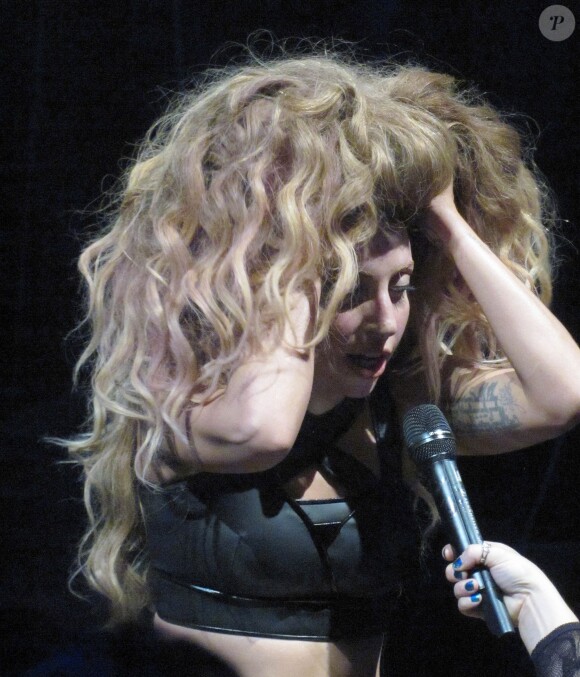 Lady Gaga sur scène lors de l'iTunes Festival à Londres, le 1er septembre 2013. Elle s'apprête à enlever son imposante perruque blonde.