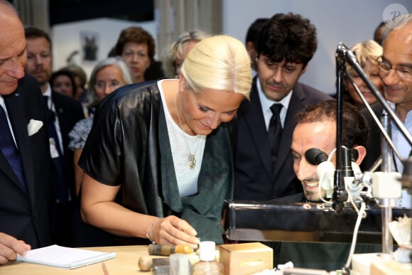 Une visiteuse méticuleuse... La princesse Mette-Marit de Norvège au Grand Palais à Paris le 11 septembre 2013 pour l'inauguration de la biennale d'arts créatifs, Révélations, en présence du ministre des Affaires Etrangères Laurent Fabius.