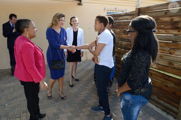 Valérie Trierweiler, portant le sac Dolly signé Gérard Darel, et Christiane Taubira lors d'une rencontre avec des militants et militantes de la cause homosexuelle ainsi qu'un couple de lesbiennes noires dans un township d'Afrique du Sud, à Kyalami, le 14 octobre 2013