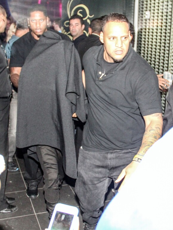 Le chanteur Justin Beiber sort d'une maison close et se cache sous une couverture à Rio de Janeiro, le 1er novembre 2013.