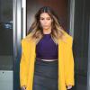 Kim Kardashian, lumineuse dans un manteau jaune Max Mara porté avec un crop top violet, une jupe Lanvin et des sandales Tom Ford, quitte l'appartement de son fiancé Kanye West situé dans le quartier de SoHo. New York, le 20 novembre 2013.