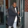 Kanye West, chic en manteau Lanvin, chemisier blanc, jean et baskets à franges Visvim, sort de son appartement à SoHo. New York, le 20 novembre 2013.
