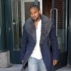 Kanye West, chic en manteau Lanvin, chemisier blanc, jean et baskets à franges Visvim, sort de son appartement à SoHo. New York, le 20 novembre 2013.