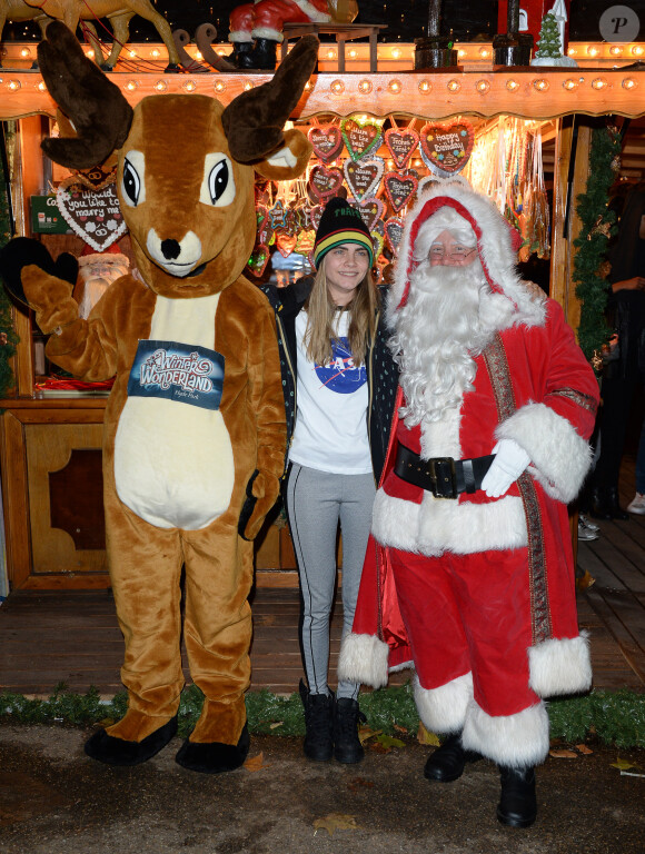 Cara Delevingne, entre un renne et le Père Noël, assiste au soir d'ouverture du parc d'attractions Winter Wonderland à Londres. Le 21 novembre 2013.