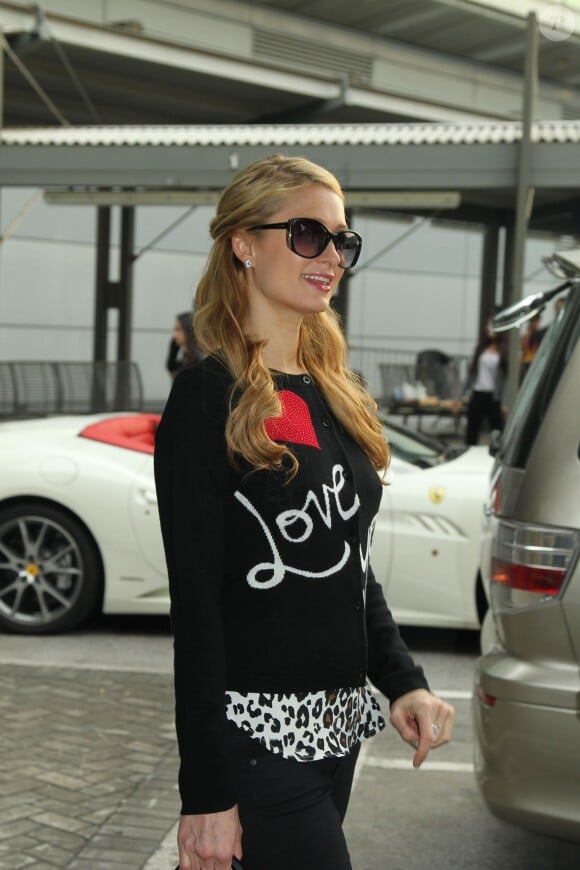 Paris Hilton pose devant les photographes à son arrivée à l'aéroport de Hong Kong, le 20 novembre 2013.