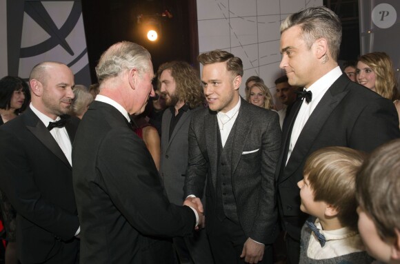Le prince Charles saluant Olly Murs sous le regard de Robbie Williams lors de la Royal Variety Performance du 25 novembre 2013 au Palladium, à Londres.