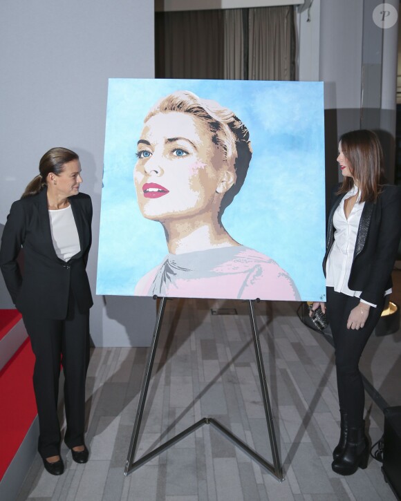 La princesse Stéphanie de Monaco, présidente de Fight Aids Monaco, et sa fille Pauline Ducruet posant près d'un portrait de Grace Kelly lors du gala et de la vente aux enchères au profit de l'association de lutte contre le sida, le 1er décembre 2013 au Méridien de Monte-Carlo.