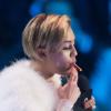 Miley Cyrus fume un joint lorsqu'elle va recevoir son prix aux MTV European Music Awards (EMA) 2013 au Ziggo Dome à Amsterdam, le 10 novembre 2013.