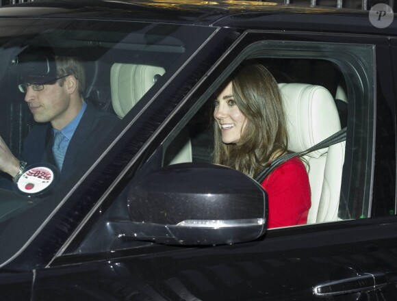 Kate Middleton et le prince William, avec leur fils le prince George de Cambridge, arrivant à Buckingham Palace le 18 décembre 2013 pour le déjeuner de Noël en famille offert par la reine Elizabeth II