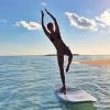 Gisele Bündchen, en bikini sur une planche de surf, se dore la pilule au soleil.