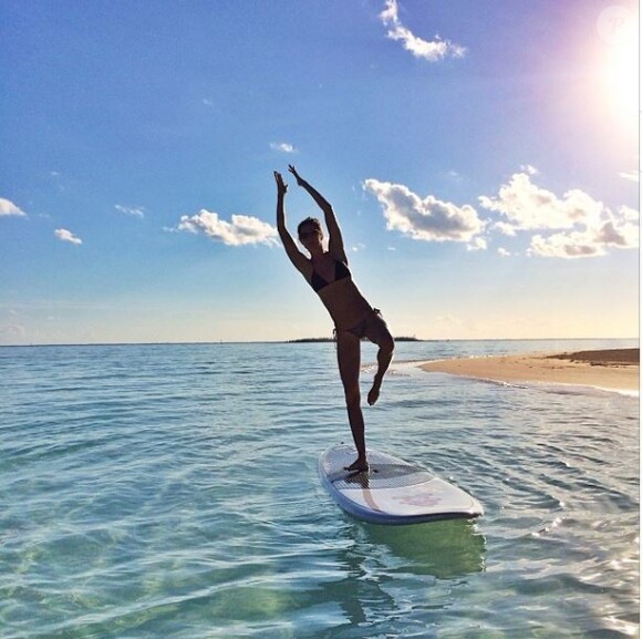 Gisele Bündchen, en bikini sur une planche de surf, se dore la pilule au soleil.