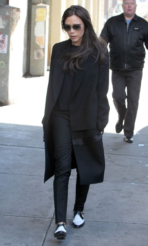 Victoria Beckham, de sortie à New York en période de Fashion Week, porte avec brio sa tenue black & white composée de lunettes et d'un manteau Victoria Beckham, un pantalon et des souliers Saint Laurent. Le 11 février 2014.