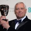 Peter Greenaway soulève son award récompensant une contribution exceptionnelle au cinéma britannique lors des BAFTA, le 16 février 2014 à Londres.
