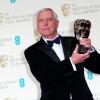 Peter Greenaway soulève son award récompensant une contribution exceptionnelle au cinéma britannique lors des BAFTA, le 16 février 2014 à Londres.