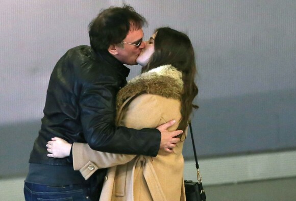 Quentin Tarantino embrasse une mystérieuse inconnue dans le hall de l'aéroport Roissy Charles-de-Gaulle à Paris, le 27 février 2014.