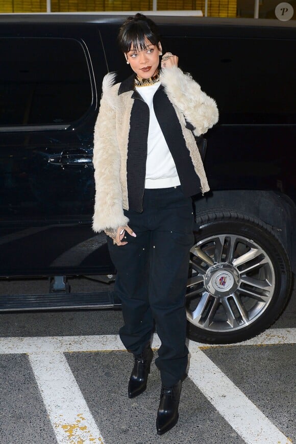 Rihanna, apprêtée pour un rendez-vous chez le dentiste, porte une veste Lanvin sur un top blanc et un pantalon Carhartt, un sac à dos Stella McCartney et un collier Annelise Michelson. New York, le 18 mars 2014.