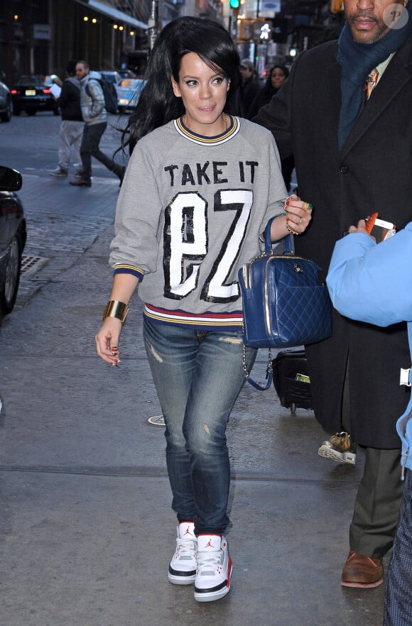 Lily Allen, surprise en pleine séance shopping à New York, porte un pull Ashish, un sac Chanel et des baskets Nike Air Jordan III (modèle Fire Red). Le 18 mars 2014.