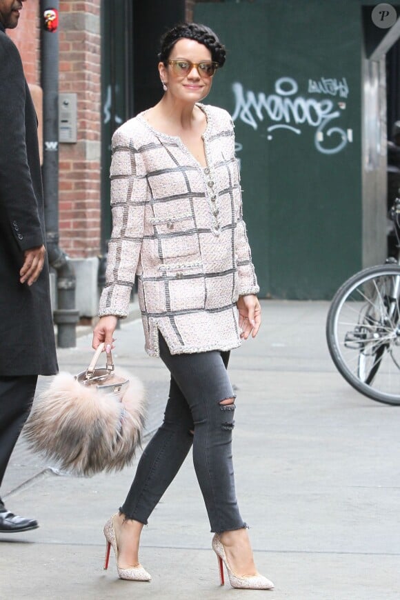 Lily Allen, radieuse dans le quartier de SoHo à New York, porte une veste rose en tweed Chanel, un sac Fendi et des souliers Christian Louboutin. Le 20 mars 2014.