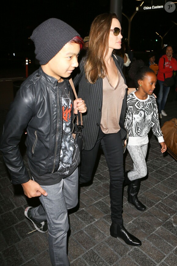 Angelina Jolie avec deux de ses six enfants Maddox et Zahara à l'aéroport de Los Angeles le 25 mars 2014. Ils étaient à Las Vegas où se déroulait une conférence dans le cadre du CinemaCon et la présentation du film d'Angie, Unbroken