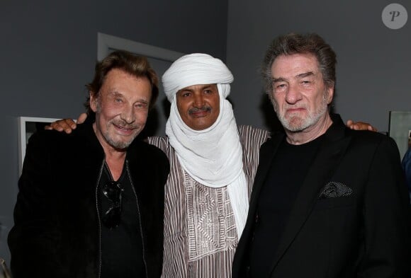 Exclusif - Johnny Hallyday, Mohamed Ixa (association "Les puits du désert") et Eddy Mitchell au Théâtre de Paris, après la représentation de la pièce Un singe en hiver, à Paris le 1er avril 2014.