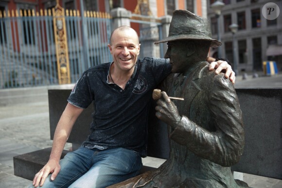 Exclusif - Pierre Simenon (Fils cadet de Georges Simenon et frère de Marc Simenon, le mari de Mylène Demongeot, et auteur du livre "Au nom du sang versé") pose avec la statue de Georges Simenon sur un banc dans les rues de Liège, le 27 avril 2014.