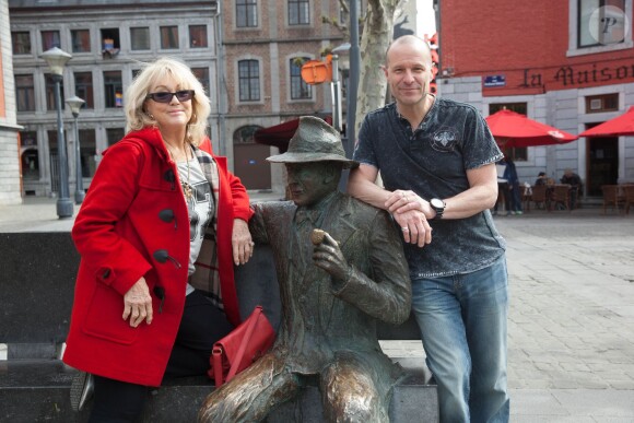 Exclusif - Mylène Demongeot et Pierre Simenon (Frère de Marc Simenon, le mari de Mylène Demongeot, et fils cadet de Georges Simenon, et auteur du livre "Au nom du sang versé") posent avec la statue de Georges Simenon sur un banc dans les rues de Liège, le 27 avril 2014.
