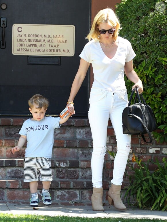 January Jones, maman stylée en top et jean blanc, sac Givenchy (modèle Lucrezia) et bottines Rag & Bone, quitte un cabinet médical avec son fils Xander. Brentwood, Los Angeles, le 29 avril 2014.