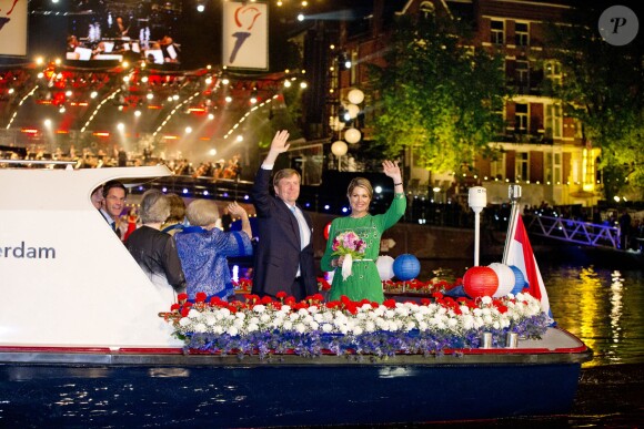 Le roi Willem-Alexander, la reine Maxima et la princesse Beatrix des Pays-Bas saluant la foule, le 5 mai 2014 à Amsterdam, lors de la parade fluviale au cours des festivités organisées dans le cadre du Concert de la Liberté pour la Fête de la Libération.