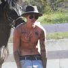 Justin Bieber fait du cheval à Los Angeles, le 12 mai 2014. Le jeune chanteur exhibe (pour la énième fois) ses tatouages.