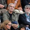 Raymond Domenech et sa compagne Estelle Denis assistent aux Internationaux de France de tennis de Roland Garros à Paris, le 27 mai 2014.