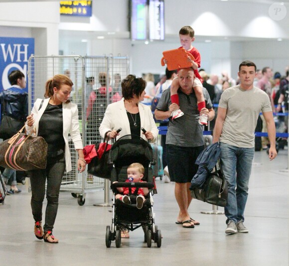 Coleen Rooney en route pour le Brésil avec ses beaux-parents et ses enfants, Kai et Klay, à Manchester, le 16 juin 2014