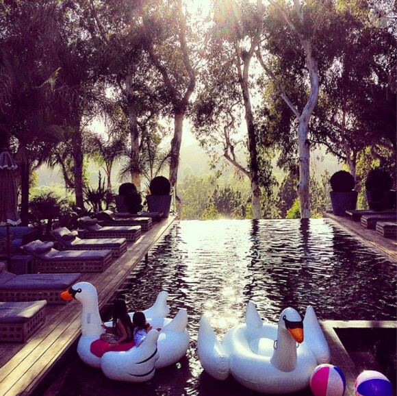 Jade et Joy naviguent sur une énorme cygne dans la piscine familiale. Une photo de Laeticia Hallyday postée sur son compte Instagram, le 21 juin 2014.