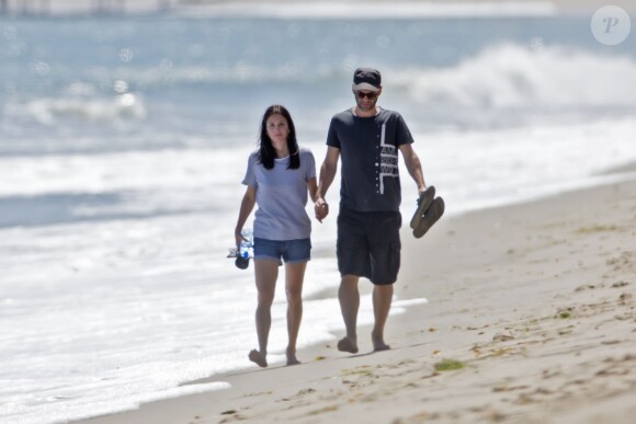 Exclusif - Courtney Cox et son petit-ami Johnny McDaid lors d'une balade romantique main dans la main sur la plage à Malibu, le 30 mai 2014. 