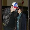 Exclusif - Ashton Kutcher et sa fiancée Mila Kunis enceinte arrivent à Los Angeles en provenance de l'Iowa où ils ont rendu visite aux parents d'Ashton, le 30 mars 2014.