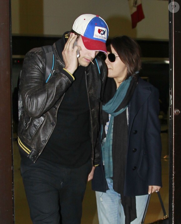 Exclusif - Ashton Kutcher et sa fiancée Mila Kunis enceinte arrivent à Los Angeles en provenance de l'Iowa où ils ont rendu visite aux parents d'Ashton, le 30 mars 2014.