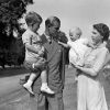 La princesse Anne enfant dans les bras de la reine Elizabeth II en août 1951 à Clarence House. Le prince Philip tient lui le prince Charles.
