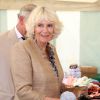 La duchesse de Cornouailles achetant une poupée de petit ramoneur pour le prince George de Cambridge. Le prince Charles et Camilla Parker-Bowles visitaient le Sandringham Flower Show le 30 juillet 2014, dans le Norfolk.