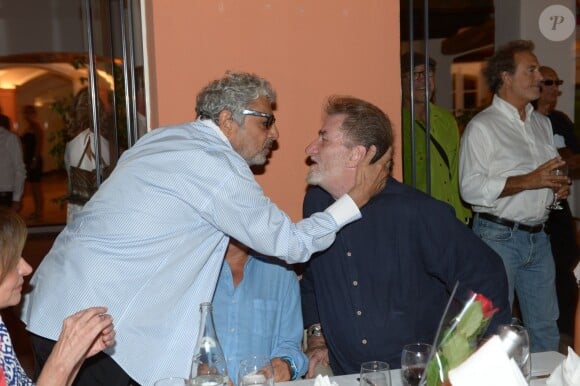 Eddy Mitchell et Enrico Macias au restaurant La Bouillabaisse à Saint-Tropez, à l'occasion d'un dîner organisé par Marcel Campion, le 6 août 2014.
