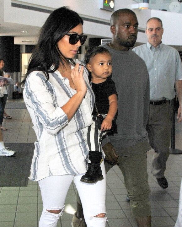 Kim Kardashian, son mari Kanye West et leur fille North à l'aéroport de Los Angeles. Le 1er septembre 2014.